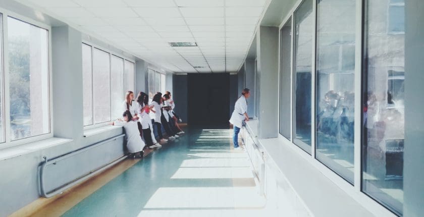 image of nurses hanging out in hospital hall for blog post on how to avoid hospital drama as a travel nurse